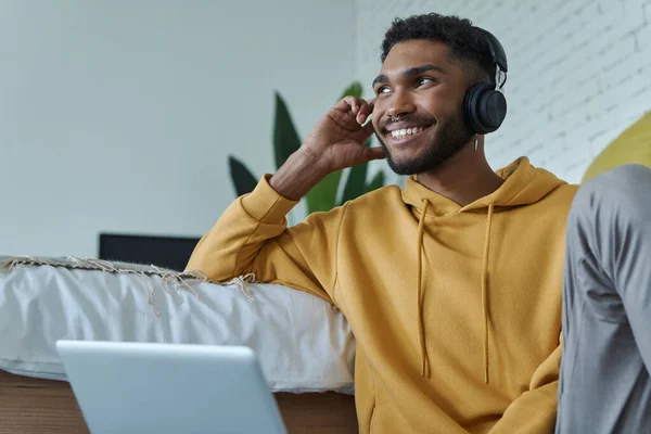 Handsome African Man Headphones Using Laptop While Sitting Floor Bed — Stockfoto