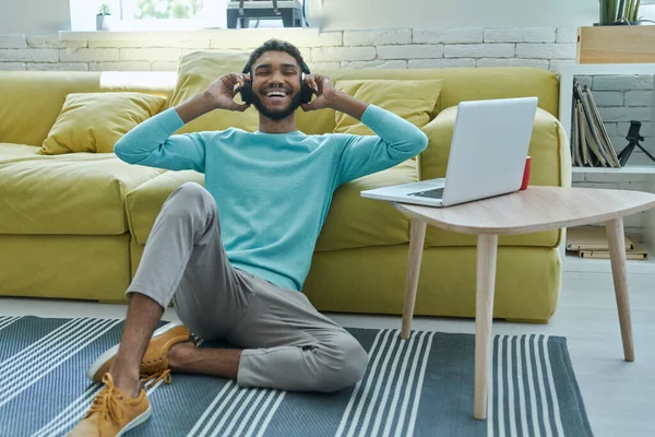 Veselý Africký Muž Sluchátkách Těší Hudbu Zatímco Sedí Doma Podlaze — Stock fotografie