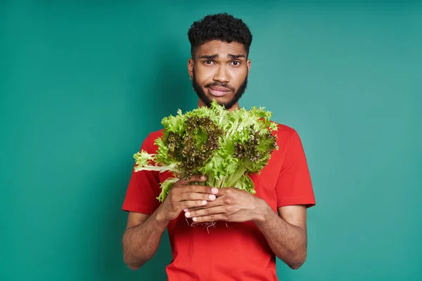 Frustrated African Man Holding Bunch Lettuce Green Background — Foto de Stock