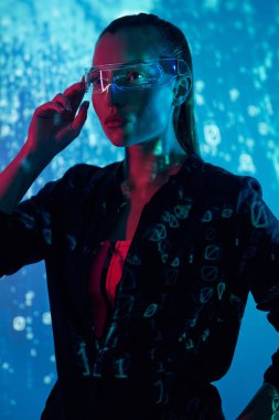 Fütürist gözlükleri renkli arka plana göre ayarlayan güzel bir genç kadın.