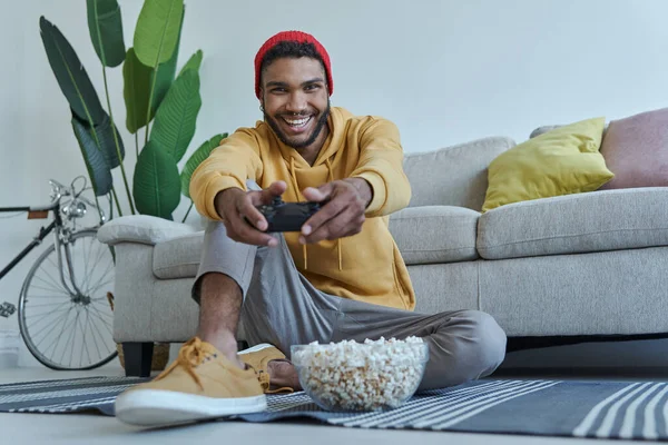 Joyful Young African Man Playing Video Games While Sitting Floor — Stockfoto