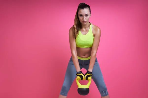 Piękna Młoda Kobieta Ćwiczy Kettlebell Różowym Tle — Zdjęcie stockowe