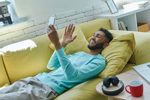 Alegre Homem Africano Ter Vídeo Chamada Gestos Enquanto Relaxa Sofá — Fotografia de Stock