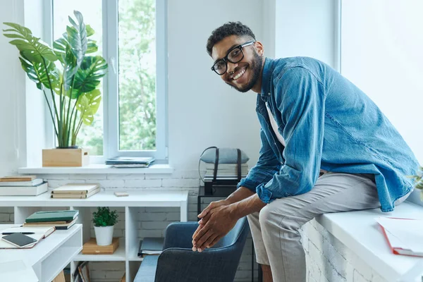 Confident African Man Looking Camera While Sitting Window Sill Office — Photo