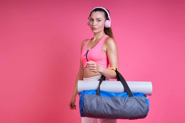 Confident Young Woman Sports Clothing Carrying Bag Pink Background — Foto de Stock