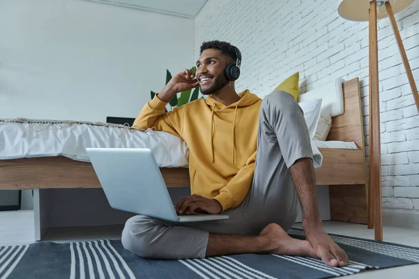 Cheerful African Man Headphones Using Laptop While Sitting Floor Bed — 스톡 사진
