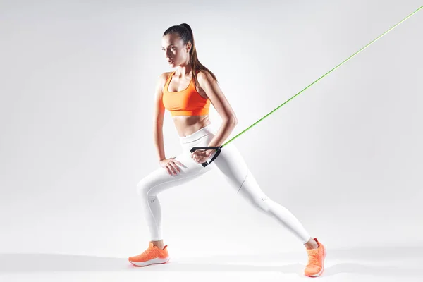 Confident Woman Sports Clothing Using Resistance Band While Exercising White — Stockfoto