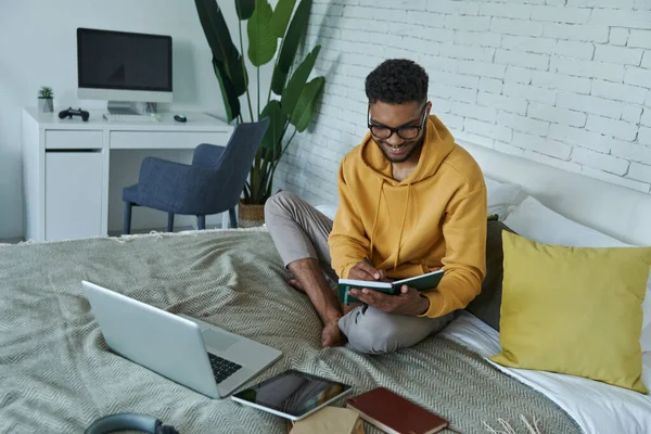 Top View Cheerful African Man Making Notes While Sitting Bed — 图库照片