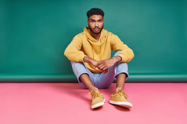 Handsome African Man Looking Camera While Sitting Colorful Background —  Fotos de Stock