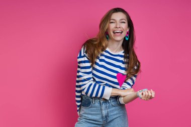 Renkli arka planda dururken gülümseyen güzel bir genç kadın.