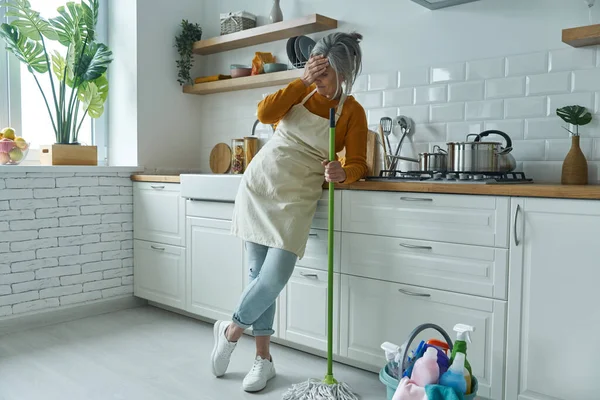 Full Length Tired Senior Woman Leaning Mop While Standing Domestic — Stock Photo, Image