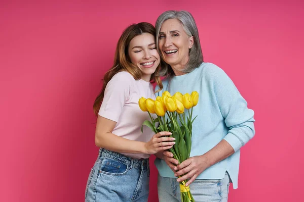 Happy Senior Mother Adult Daughter Holding Bunch Tulips Pink Background — Stockfoto