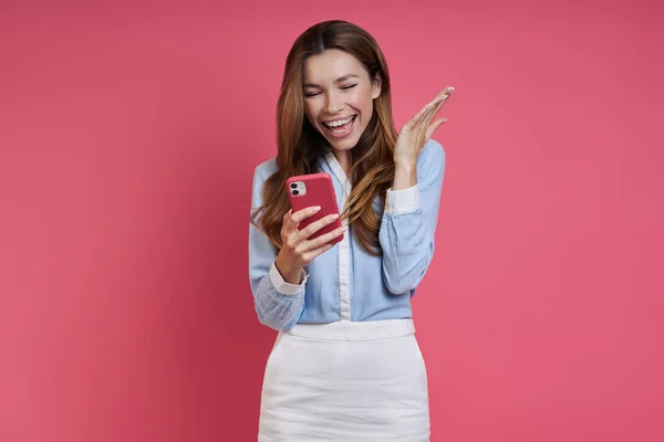 Mujer Joven Feliz Mirando Teléfono Inteligente Haciendo Gestos Mientras Está — Foto de Stock