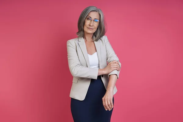 Confident Senior Woman Rolling Sleeve Her Jacket While Standing Pink — Foto Stock