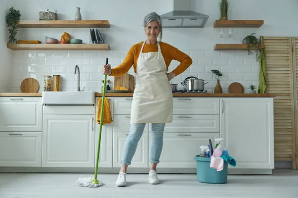 Confident Senior Woman Carrying Mop While Standing Domestic Kitchen — Stock Fotó