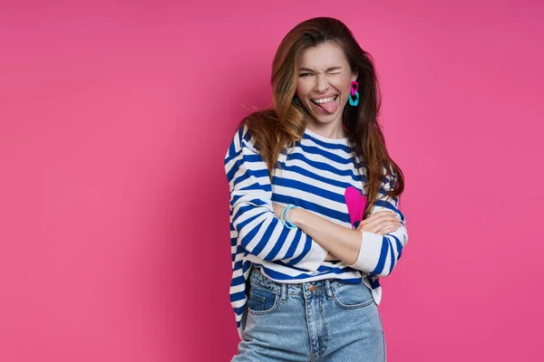 Playful Young Woman Sticking Out Tongue While Standing Colored Background — Stockfoto