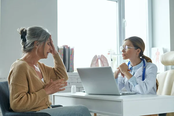Depressed Senior Woman Touching Head While Sitting Front Doctor — Stock Photo, Image