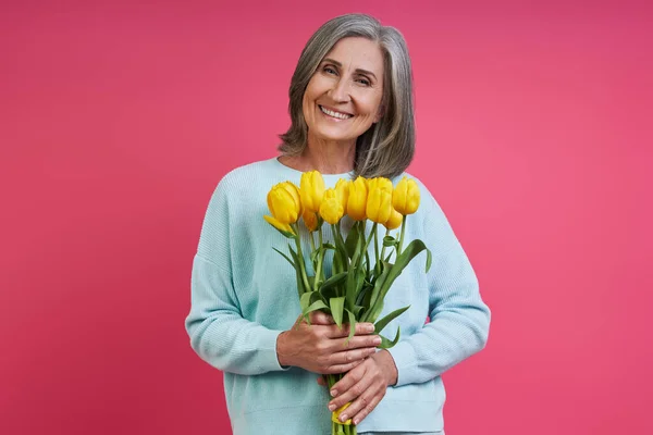 Happy Senior Woman Holding Bunch Tulips While Standing Pink Background — Foto de Stock