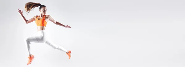 Confident Young Woman Sports Clothing Jumping White Background — Φωτογραφία Αρχείου