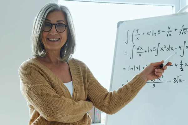 Vrolijke Oudere Vrouw Die Whiteboard Wijst Terwijl Klas Staat — Stockfoto