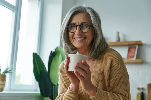 Cheerful Senior Woman Enjoying Hot Drink While Relaxing Home — Stockfoto