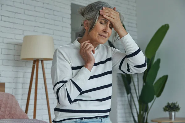 Senior Woman Suffering Headache While Sitting Bed Home — Fotografie, imagine de stoc