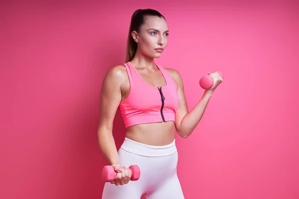 Sebevědomá Mladá Žena Sportovním Oblečení Cvičení Činky Proti Růžové Pozadí — Stock fotografie