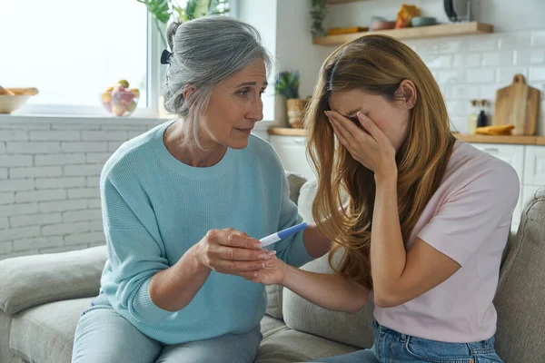 Depressed Young Woman Holding Pregnancy Test While Her Mother Consoling — Φωτογραφία Αρχείου