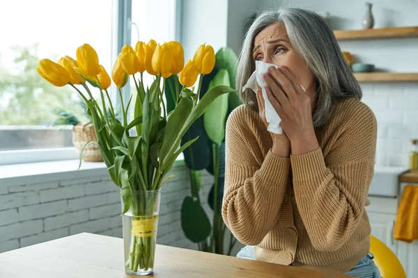 Senior Woman Sneezing While Sitting Bunch Tulips Home — ストック写真