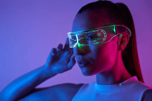 Confident Young Woman Adjusting Futuristic Glasses Dark Background — 图库照片