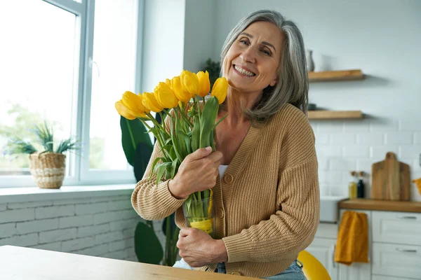 Happy Senior Woman Holding Bunch Yellow Tulips While Standing Domestic — Foto de Stock