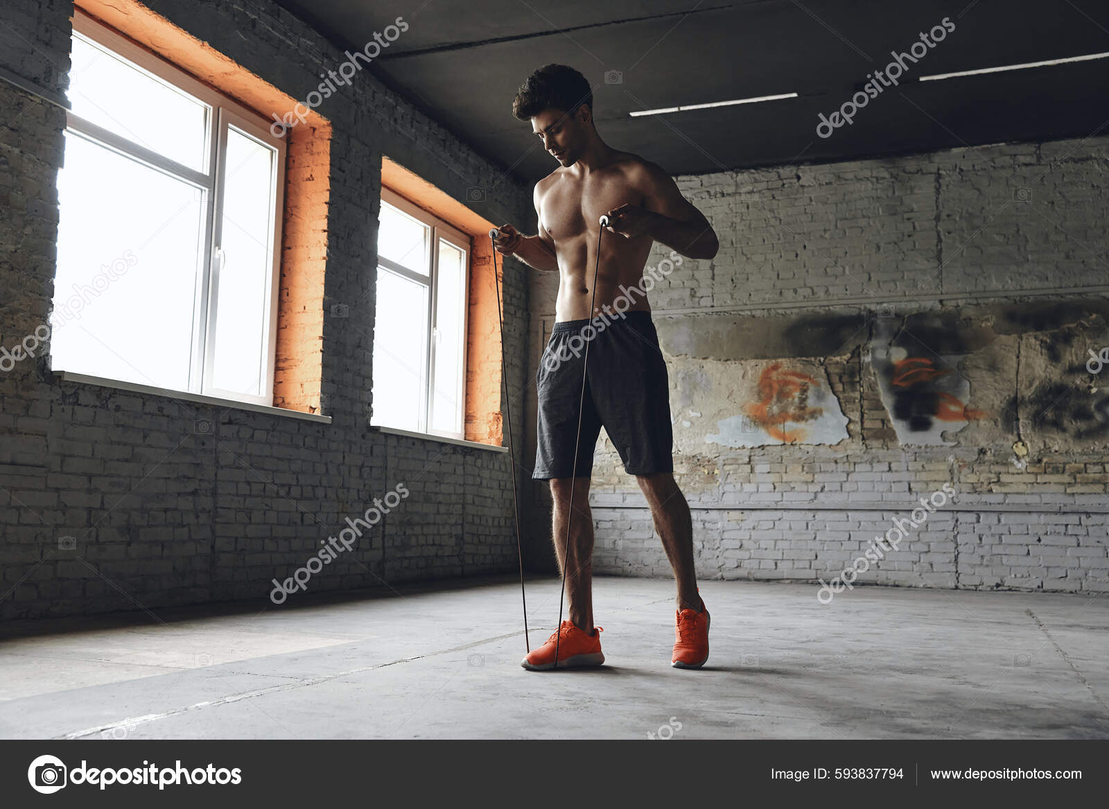 Full Length Confident Young Man Stretching Jumping Rope While Standing Stock Photo gstockstudio 593837794