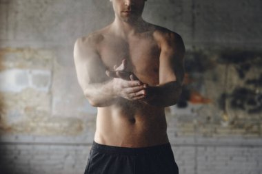 Close-up of young man preparing hands with talcum powder before training