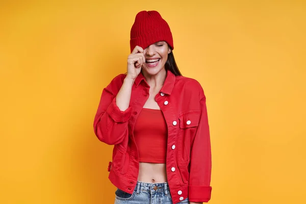 Playful Young Woman Adjusting Her Hat Smiling Yellow Background — Stock Fotó