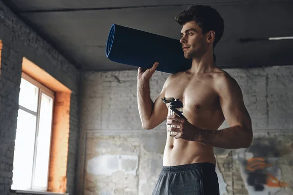 Confident Young Man Carrying Exercise Mat Bottle Water While Standing — Stok fotoğraf