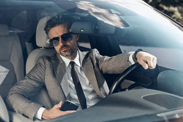 Confident Mature Man Formalwear Holding Smart Phone While Driving Car — ストック写真