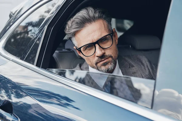 Confident Mature Businessman Looking Out Window While Sitting Back Seat — Foto Stock
