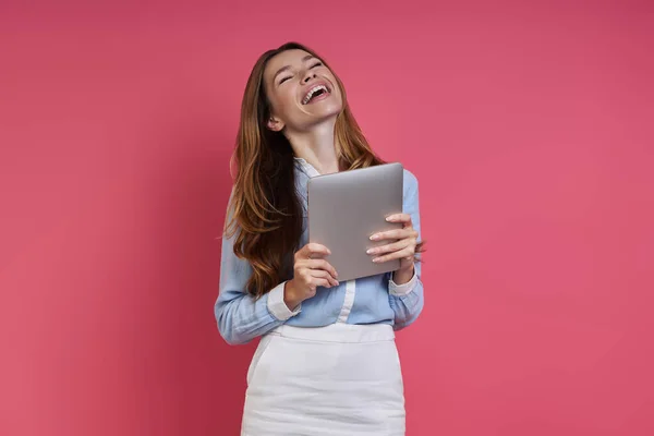 Excited Young Woman Holding Digital Tablet Keeping Eyes Closed Colored — стоковое фото