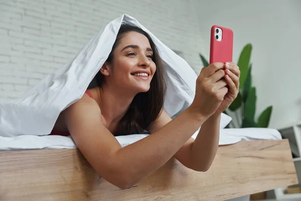 Beautiful Young Woman Covering Blanket While Using Smart Phone Bed — Stock Fotó