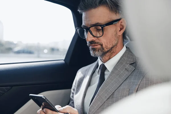 Confident Mature Businessman Using Smart Phone While Sitting Car — 图库照片