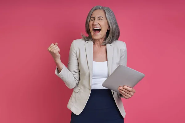 Happy Senior Woman Holding Digital Tablet Gesturing While Standing Pink — Stock Photo, Image