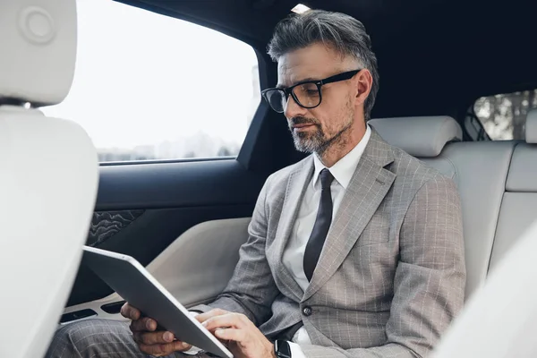 Confident Mature Businessman Working Digital Tablet While Sitting Back Seat — 图库照片