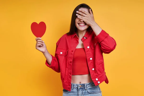 Beautiful Young Woman Holding Paper Heart Covering Eyes Hand Yellow — Stockfoto
