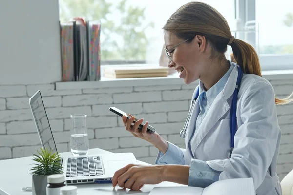 Confident Female Doctor Using Smart Phone Smiling While Sitting Medical — Foto de Stock