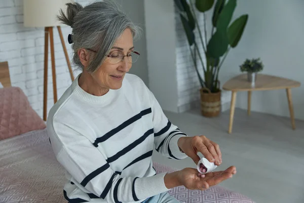 Confident Senior Woman Taking Medicines While Sitting Bed Home — Fotografia de Stock