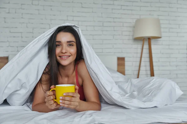 Beautiful Woman Looking Out Blanket Holding Coffee Cup While Lying — Stock Fotó