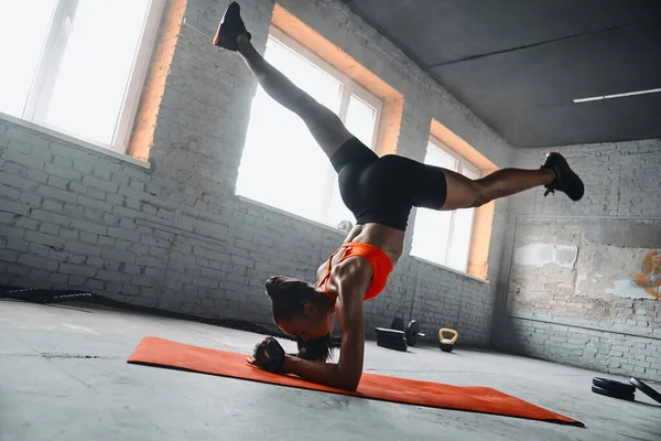 Confident Young African Woman Doing Handstand Splits Gym — Stockfoto