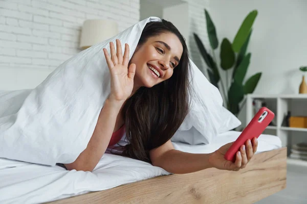 Beautiful Young Woman Covering Blanket While Using Smart Phone Bed — Stockfoto