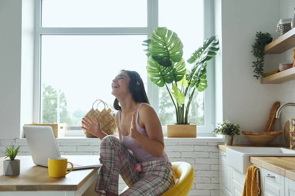 Щаслива Жінка Навушниках Використовуючи Ноутбук Жестикуляцію Сидячи Кухонній Стійці — стокове фото