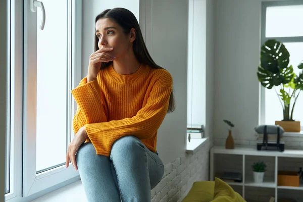 Worried Young Woman Looking Window While Sitting Window Sill — Foto de Stock